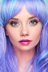 Naklejka premium close-up portrait of sensual young woman with blue hair looking at camera isolated on blue