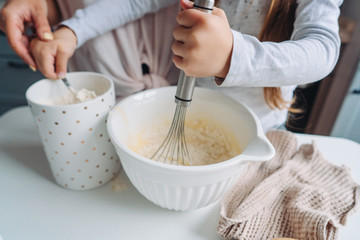 mom teaches her little daughter to cook food