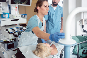 Team of doctors performing endoscopy in hospital examining stomach of patient 