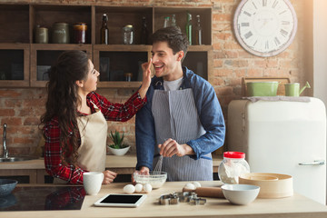 Happy young couple baking in loft kitchen
