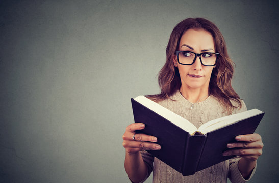 Curious nerd woman reading book