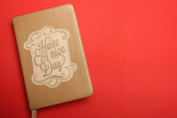 Notebook with text of a Have a nice day on a red background