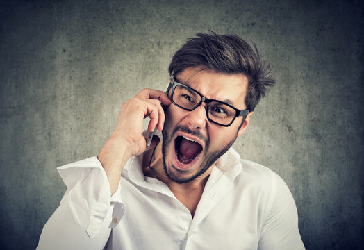 Angry man speaking on phone and yelling