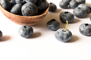 Fresh blueberries in a wooden spoon on a white background. Close up. The concept of natural food
