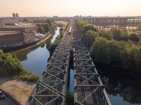 Sunset sunrise on polluted cityscape with rail bridge and canal river