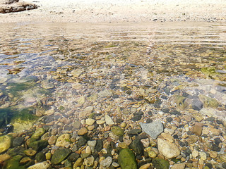 background of beach view from the sea. beautiful stones under the sea water