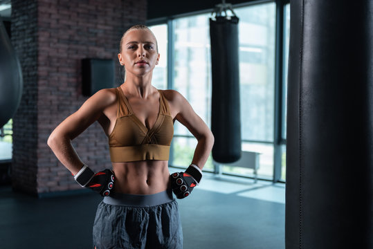 Athletic woman. Appealing athletic woman feeling inspired and joyful while standing in light spacious gym