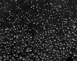 on a black background many drops of rain gradient size from big to small