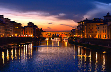 colorful sunset with lights on Ponte Vecchio bridge in Florence, Italy