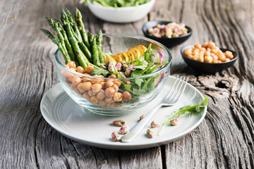 Vegetarian salad, Buddha bowl with asparagus, arugula, zucchini, kohlrabi, pistachio and chickpeas. Selective focus