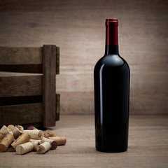 Weinflasche mit Weinkiste und Korken auf Holztisch