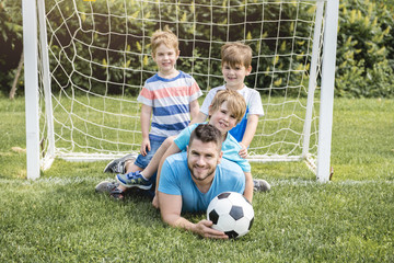 Man with child playing football outside on field