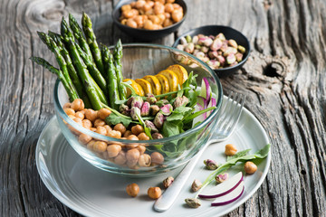 Vegetarian salad, Buddha bowl with asparagus, arugula, zucchini, kohlrabi, pistachio and chickpeas. Selective focus