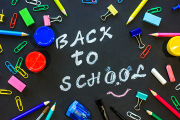 Text back to school on black chalkboard and stationery