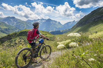 Fototapeta na wymiar active senior woman, riding her e-mountainbike in the Arlberg area near Lech,Tirol,Austria