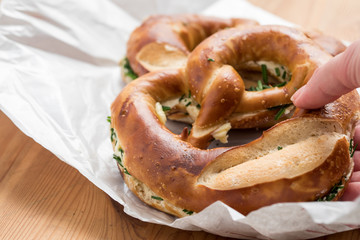 Frau isst Deutsche Spezialität  Butterbrezel mit Schnittlauch