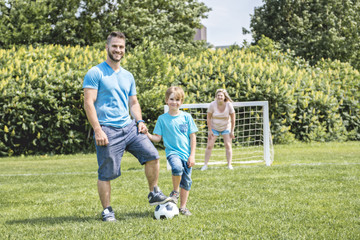 Man with child playing football outside on field
