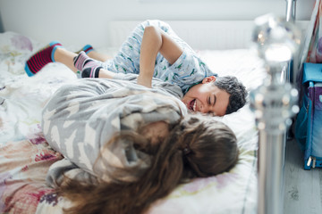 Siblings Playfighting in Bed