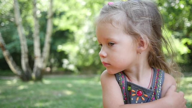 Little child girl portrait itches from mosquito bites during nature park picnic