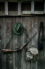 Poster Professionele jagersuitrusting voor de jacht. Geweer, hoed, tas en anderen op een houten zwarte achtergrond. © tibor13