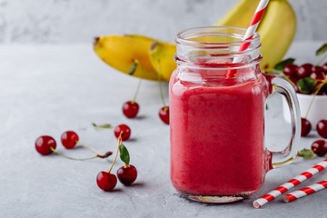 Cherries and banana smoothie in glass mason jar