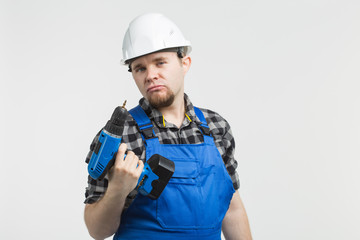 Funny builder standing with screwdriver on white background