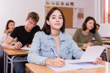 schoolgirl is sitting test and answer about task © JackF
