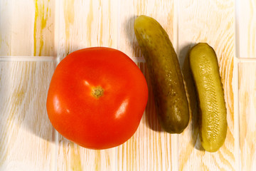 pickled cucumbers and tomatoes on wooden background