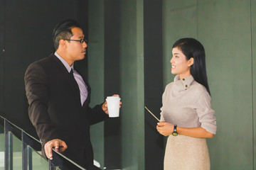 Managers and secretaries are walking at the corridors of the office and discussing about the work