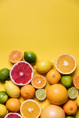Citrus fuits, grapefruit, lemon, lime, orange on a yellow background