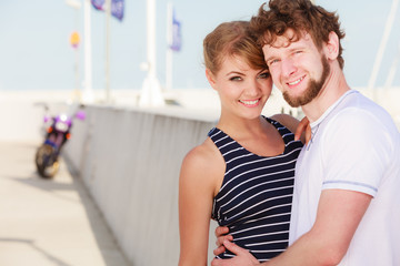 Tourist couple in marina with motorcycle