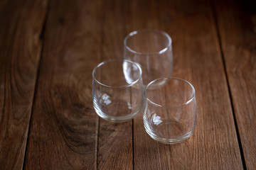 Three empty glasses on a brown wooden desk