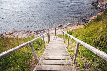 Obraz premium Wooden paths stairs along the coast on the island of Suomenlinna, a beautiful seascape. Islands of Finland