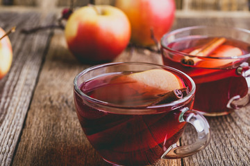 Hot drink with apple cider, sliced fruit and cinnamon stick
