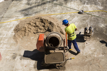 Obrero haciendo hormigón en obra de construcción.