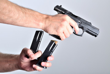 Man reloading pistol gun after shooting isolated