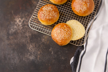 Homemade Hamburger Buns Topped with Sesame Seeds on a Rustic Black Background