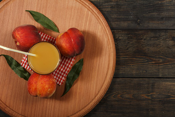 Peach fresh juice with fresh peaches on a dark background. Top view, copy space. Healthy eating. Fresh juice with peach. Fresh peaches healthy food.
