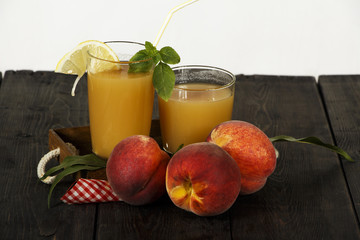Peach fresh juice with fresh peaches on a dark background. Top view, copy space. Healthy eating. Fresh juice with peach. Fresh peaches healthy food.
