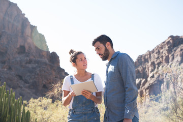 Man and woman standing next to cactus