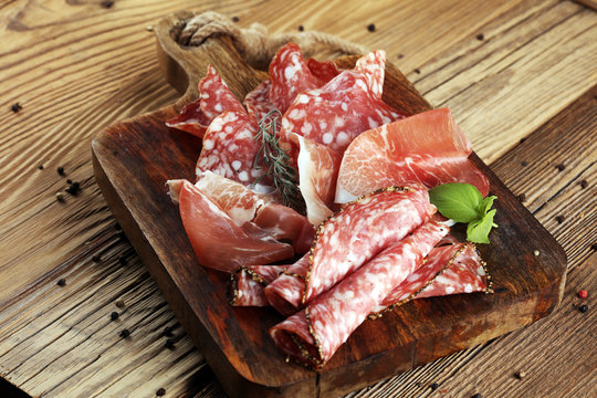 Food tray with delicious salami, raw ham and italian crudo or jamon. Meat platter with selection