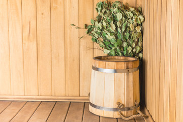 Wooden pail with birch broom in the sauna