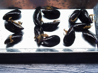 Word Sea written with raw mussels on a silver tray