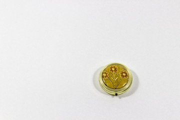 Ornamented shinny reflective single golden pill box with white background