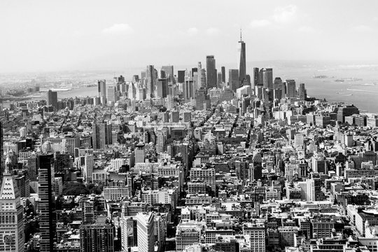 Fototapeta Cityscape skyline of various buildings, skyscrapers and architecture looking down on midtown Manhattan in New York City towards downtowns Financial District in black and white