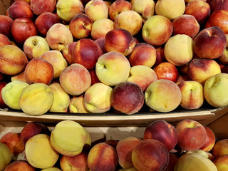 Fresh appetizing peaches lie in the shop window
