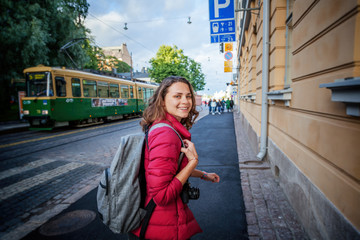 Beautiful happy young woman girl tourist hiker walks the streets in Helsinki, Finland, travel to...
