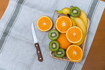 Fresh fruits in basket and knife. Top view. Place for text.
