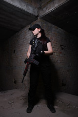 Fototapeta na wymiar Armed girl in dark room