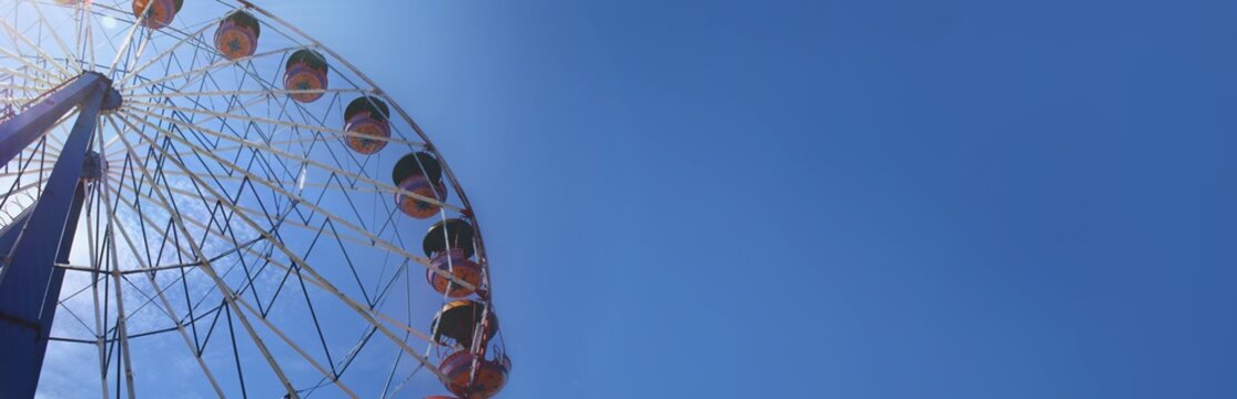 A carousel standing in the sunshing on background a blue sky